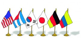 Six flags displayed on stands, representing different nationalities: the USA, Argentina, South Korea, Japan, Germany, and Colombia. The flags are arranged from left to right.