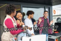 A group of four friends smiling and laughing together at an outdoor gathering, with a grill in the foreground. The text "también vs tampoco" overlays the image. The setting suggests a casual social environment.